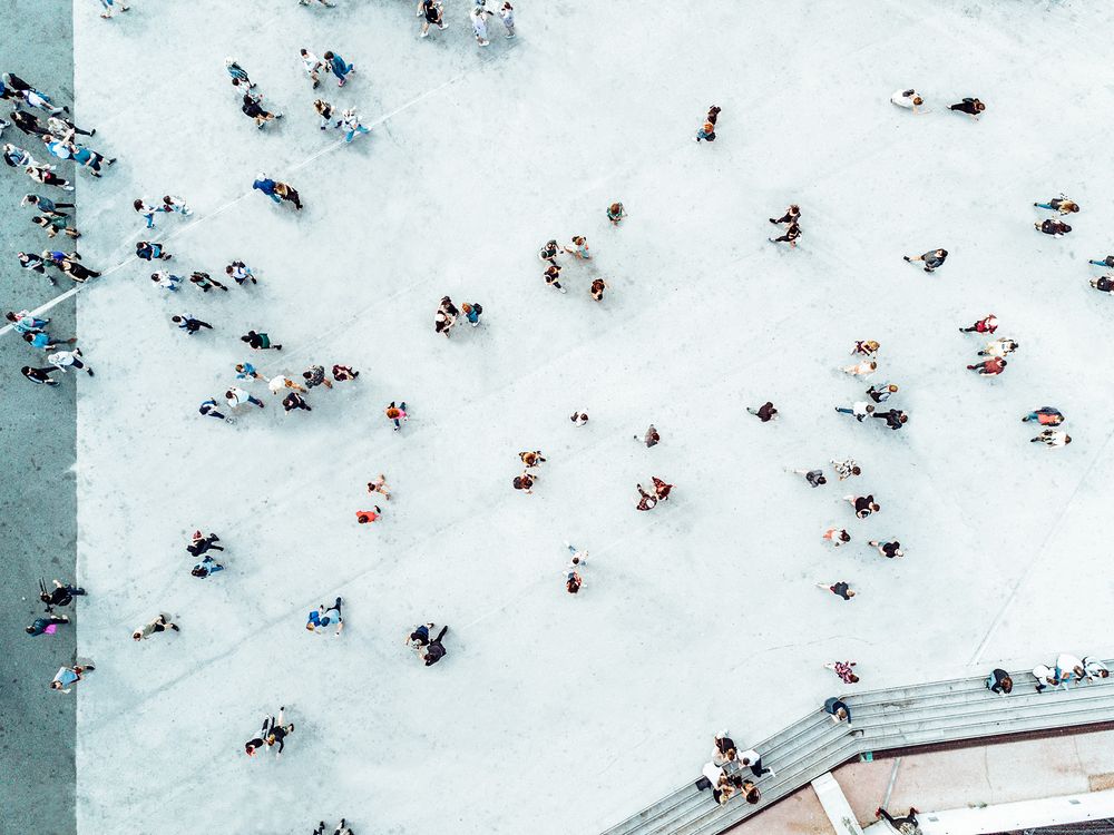 Overhead view of many people walking on concrete walkway